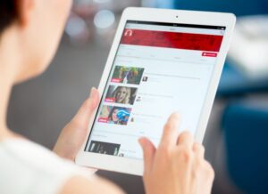 Verve News Articles Woman holding and looking at tablet with YouTube screen featured