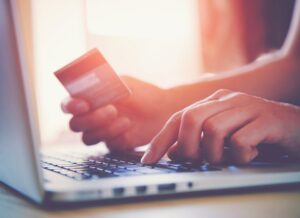 Close up of hands on a laptop with credit card in hand