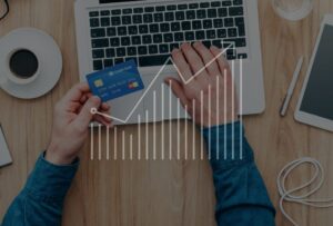 Line graph showing upwards trend, user paying online with credit card in background