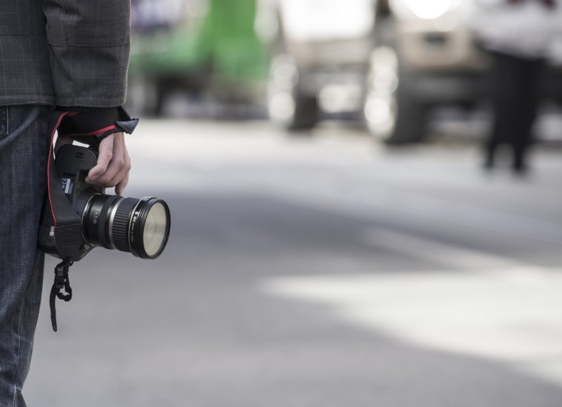 Verve News Articles Man holding camera against leg