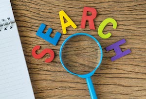 colourful letters spelling out search over magnifying glass