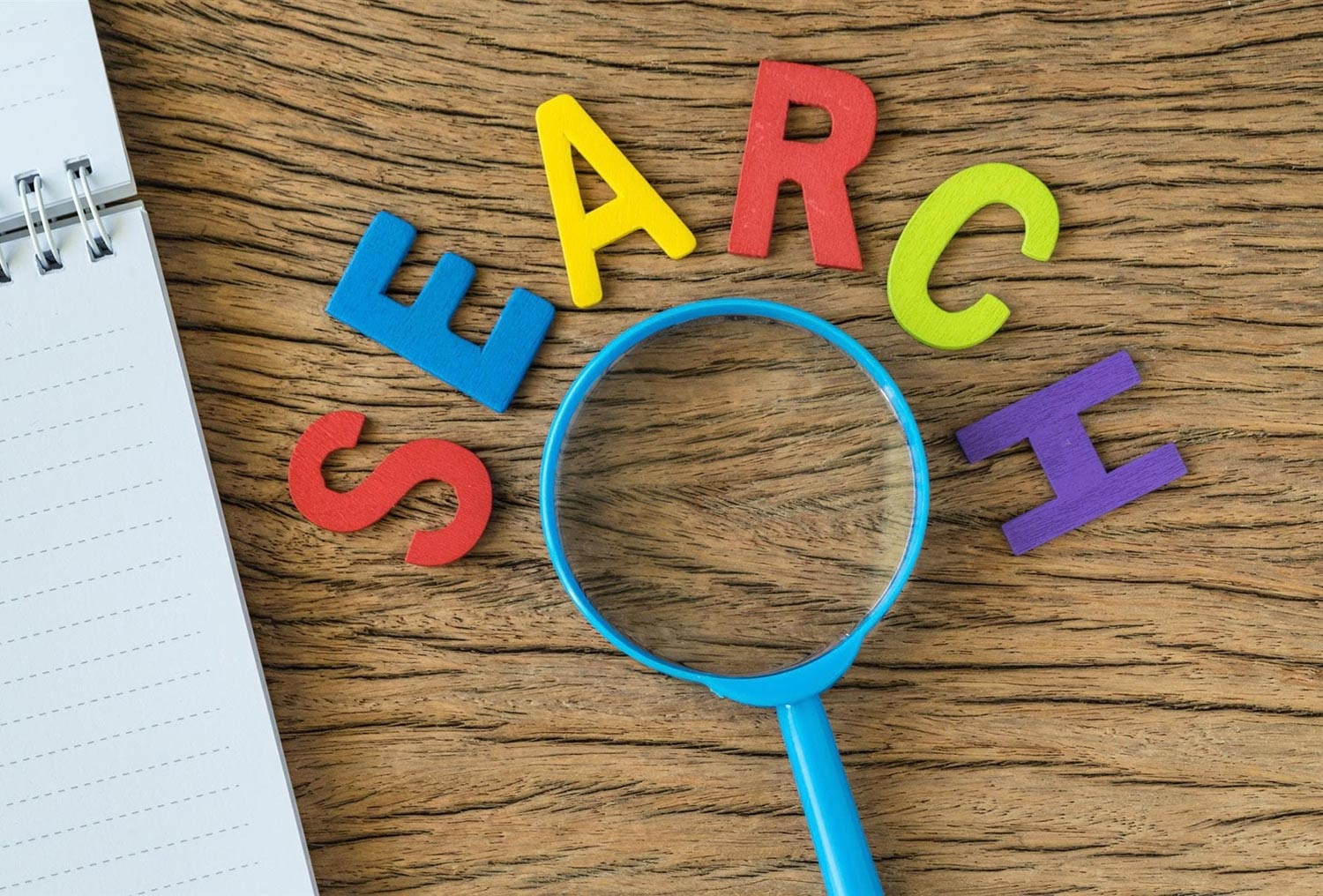 colourful letters spelling out search over magnifying glass