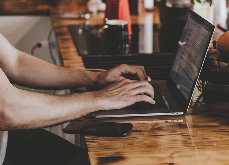 Hands typing on laptop