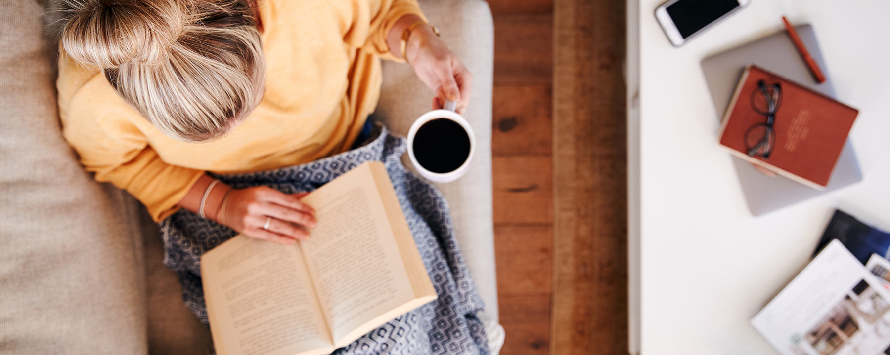 Lady reading book with coffee in hand